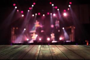 top hout bureau met licht bokeh in concert vervagen achtergrond, houten tafel foto