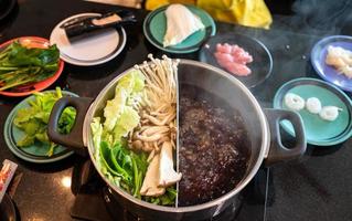 reeks van groenten en vlees voorbereidingen treffen voor eten met stoofpot. hotpot is een interactief maaltijd in welke diners zitten in de omgeving van een sudderen pot van soep Bij de centrum van de tafel met ingrediënten. foto