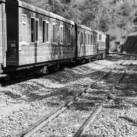 speelgoed- trein in beweging Aan berg helling, mooi visie, een kant berg, een kant vallei in beweging Aan spoorweg naar de heuvel, tussen groen natuurlijk bos.speelgoed trein van kalka naar shimla in india-zwart en wit foto