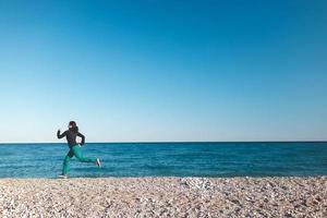 een meisje op een ochtend joggen op het strand foto