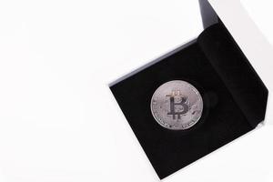 platina bitcoin in een wit geschenk doos met zwart fluweel Aan een wit achtergrond. kopiëren ruimte. foto