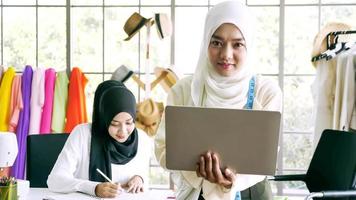 gelukkig moslim Dames werken samen Bij de kleding kantoor. foto