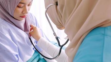 moslim vrouw dokter controle omhoog patiënten Gezondheid Bij ziekenhuis kamer. foto
