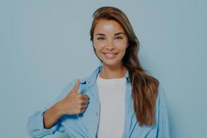 gelukkige jonge blanke vrouw met een blauw shirt met lange mouwen foto