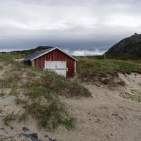 een rood botenhuis in de duinen Aan de kust van Noorwegen. foto