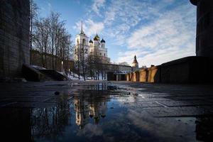 drie-eenheid kathedraal in pskov het kremlin met reflectie in de water van een voorjaar plas. foto