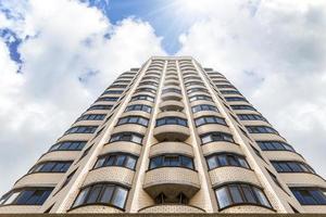 nieuw hoogbouw huis Aan een achtergrond van blauw lucht. visie van de bodem omhoog foto