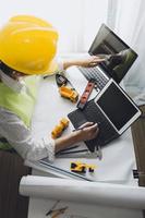 bedrijf hand- werken en laptop met Aan Aan bouwkundig project Bij bouw plaats Bij kantoor bureau in kantoor foto