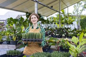 Kaukasisch tuinman is werken binnen haar kas Bij kinderkamer tuin centrum voor inheems en exotisch fabriek teler concept foto