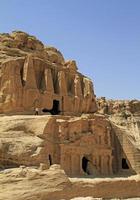 een Mens wandelingen omhoog naar de obelisk graf in petra, Jordanië foto