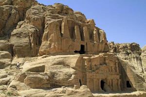 een Mens wandelingen omhoog naar de obelisk graf in petra, Jordanië foto