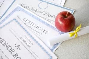 een eer rollen herkenning, certificaat van prestatie en hoog school- diploma leugens Aan tafel met klein rol en rood appel. onderwijs documenten foto