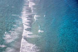 antenne visie naar golven in oceaan spatten golven. koraal rif in de Indisch oceaan, ontspannende golven surfen foto