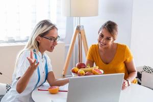 portret van jong glimlachen vrouw voedingsdeskundige in de overleg kamer met een geduldig. maken eetpatroon plan. jong vrouw bezoekende voedingsdeskundige in gewicht verlies kliniek foto