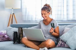 afbeelding tonen mooi vrouw boodschappen doen online met credit kaart. vrouw Holding credit kaart en gebruik makend van laptop. online boodschappen doen concept foto