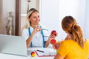 dokter voedingsdeskundige, diëtist en vrouw geduldig Aan overleg in de kantoor. vrouw voedingsdeskundige geven overleg naar geduldig. maken eetpatroon plan. foto