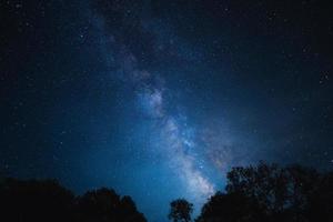 nacht tafereel melkachtig manier achtergrond, bomen tegen lucht Bij nacht foto