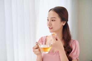 portret van jong Aziatisch vrouw aan het eten vitamine pil voor Gezondheid zorg Bij huis. foto