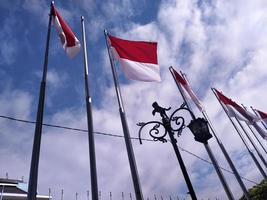 Indonesisch vlag Aan een blauw lucht achtergrond foto