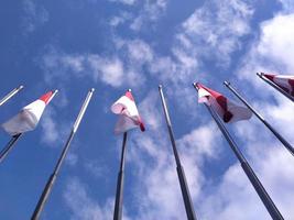 Indonesisch vlag Aan een blauw lucht achtergrond foto