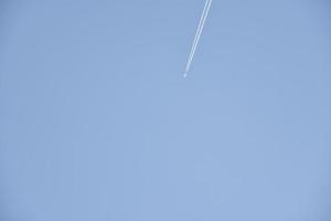 de contrail van een vliegtuig in de blauw lucht. de vlucht van een passagier vlak. foto