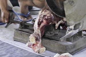 een portret van moslims snijdend vlees Aan eid al adha door gebruik makend van snijdend machine foto