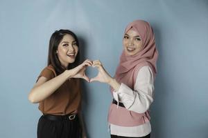 twee aantrekkelijk jong Aziatisch Dames voelt gelukkig en een romantisch vormen hart gebaar drukt uit inschrijving gevoelens en vriendschap concept foto