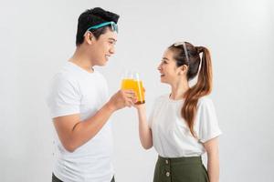 een gezond jong Aziatisch paar drinken oranje sap foto