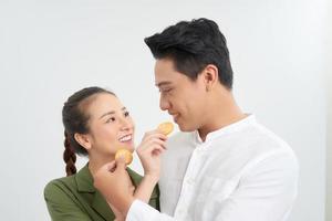 liefde en geluk. schattig lief geliefden voeden elk andere door cupcakes koekjes. foto