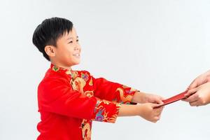 Aziatisch Vietnamees jongen ontvangen rood papier pakket of monetair van een ander Aan maan- nieuw jaar festival, met traditioneel oa dai geïsoleerd Aan wit achtergrond. foto