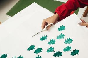 vrouw snijdend kraft papier en maken enveloppen Bij werkplaats, studio. handgemaakt en Kerstmis concept foto