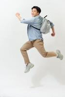 gelukkig glimlachen jong Mens met rugzak jumping in lucht over- wit achtergrond foto