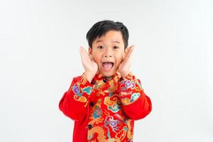 portret van een weinig Aziatisch jongen op zoek extreem verrast met zijn mond Open en handen Aan zijn gezicht foto