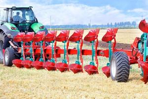 rood ploeg net zo een aanhangwagen Aan een trekker Aan de achtergrond van een agrarisch veld. 28.07.221. kiev. Oekraïne foto