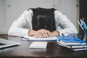 spanning bedrijf vrouw persoon van moeilijk werk, depressie in kantoor. moe en angstig werknemer vrouw met ongelukkig Bij probleem functie. jong zakenvrouw zittend verdrietig voorkant van laptop computer Aan bureau. foto