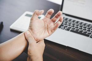 artritis persoon, vinger vrouw pijn van werken in kantoor. concept kantoor syndroom hand- pijn van beroeps ziekte, vrouw hebben pols pijn van gebruik makend van laptop computer, pols pijn. foto