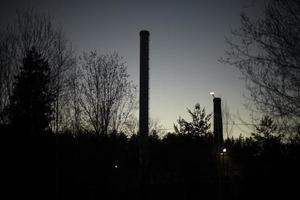 pijp van fabriek Bij nacht. silhouet van trompet. foto