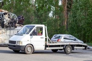 veel van oud auto's klaar voor recyclen. auto verwijdering door slepen vrachtwagen. de auto is krijgen klaar naar worden geladen op een slepen vrachtwagen. oud vernield auto's in een autokerkhof zijn aan het wachten naar worden vernietigd in een recycling park. foto