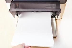 bezig met laden van blanco papier lakens in printer dienblad foto