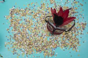 confetti verspreiding Aan blauw achtergrond met een vrouw carnaval masker foto