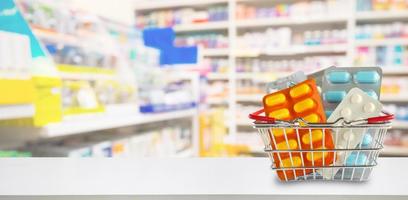 medicijnpillen pakket in winkelmandje met apotheek drogisterij planken achtergrond wazig foto