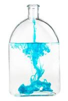 blauw inkt lost op in water in fles geïsoleerd foto
