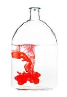 rood inkt lost op in water in fles geïsoleerd foto