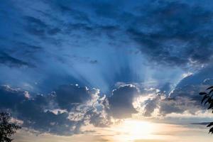 donker blauw regenachtig wolken over- zonsondergang zon foto