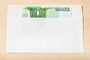 single een honderd euro Notitie in envelop Aan tafel foto