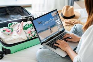 jonge vrouwen die zomervakantie plannen en informatie zoeken of hotel boeken op laptop, reisconcept foto