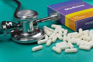 Gezondheid zorg medisch en ziekte concept. pillen en medisch uitrusting achtergrond met een drug doos nep schrijven geneeskunde foto