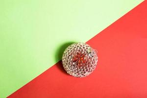 rood Kerstmis bal met transparant ijs Drempels Aan een rood groen achtergrond met geometrie en schaduw. ruimte voor tekst. kerstmis, nieuw jaar foto