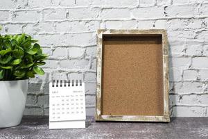 februari 2022 wit kalender met houten kader en ingemaakt fabriek Aan houten bureau. foto