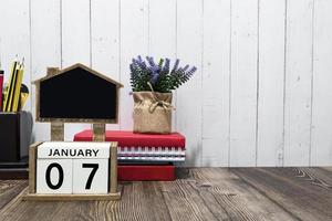 januari 07 kalender datum tekst Aan wit houten blok met briefpapier Aan houten bureau foto